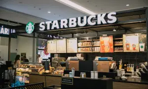 Starbucks-Theke mit leuchtendem Logo, Menütafeln und Auslagen, die die lange Starbucks-Geschichte und Kaffeekultur widerspiegeln.