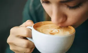 Frau trinkt Kaffee, hat aber Kreislaufprobleme nach Kaffee.