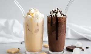 Zwei eisgekühlte Getränke, ein heller und ein dunkler, mit Sahne und Schokoladensauce. Perfekt für Caffè Mocha Rezepte.