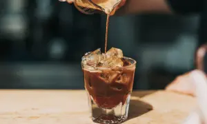 Ein Espresso wird in ein Glas mit Eis gegossen. Ist kalter Kaffee gesund? Diese erfrischende Zubereitung könnte die Antwort sein.