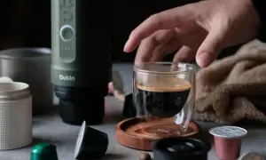 Ein Mann bereitet mit einem Outin-Gerät einen Espresso zu. Er verwendet eine Kapsel und kaltes Wasser für den perfekten instant kaffee.