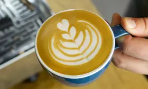 Eine Tasse Milchkaffee mit Latte Art, die das Ergebnis einer perfekten Milchkaffee Zubereitung zeigt.