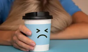 Trauriger Kaffeebecher mit traurigem Gesicht, der die Nachteile von Kaffee symbolisiert.