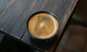Ein cremiger **white americano** mit schöner Crema auf einem rustikalen Holztisch.