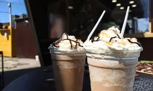 Zwei Frappuccinos mit Sahne, Schokosauce und Karamell. Ein Frappuccino ist ein kaltes Kaffeegetränk.