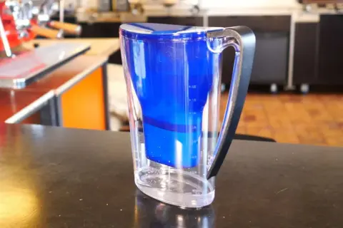 Blauer Wasserfilterkrug mit klarem Wasser. Perfekt für die Zubereitung von aromatischem Kaffee.