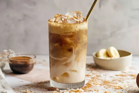 Eisgekühlter Kaffee mit Kokosraspeln und Bananenstückchen. Ein erfrischender Banana Coffee für heiße Tage.