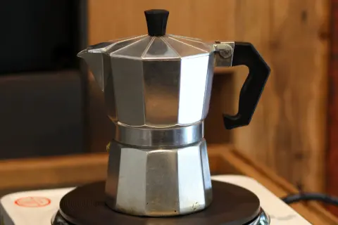 So einfach ist es, wie man einen Moka Pot benutzt: Aluminium-Kaffeekanne auf Herdplatte, bereit für aromatischen Kaffee.