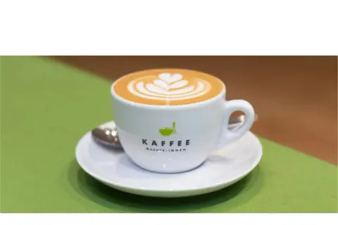 Eine Tasse Latte Art mit Herzmuster, ein Beispiel für köstliche Espresso-Varianten.