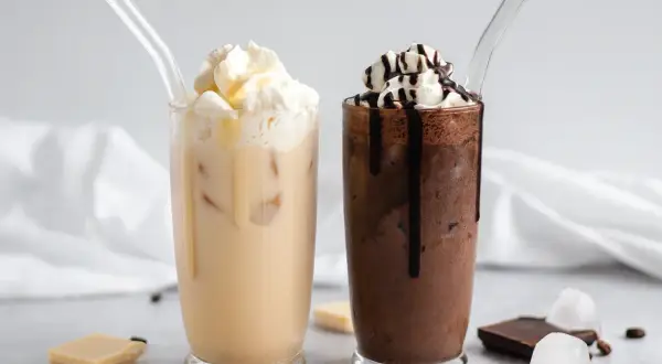 Zwei eisgekühlte Getränke, ein heller und ein dunkler, mit Sahne und Schokoladensauce. Perfekt für Caffè Mocha Rezepte.