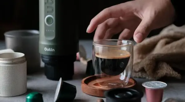 Ein Mann bereitet mit einem Outin-Gerät einen Espresso zu. Er verwendet eine Kapsel und kaltes Wasser für den perfekten instant kaffee.
