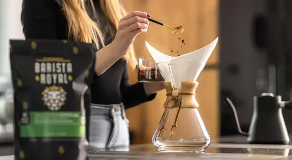 Frau bereitet Kaffee mit einer Chemex zu. Die Frage, ob man mit Espressobohnen normalen Kaffee machen kann, wird hier beantwortet.