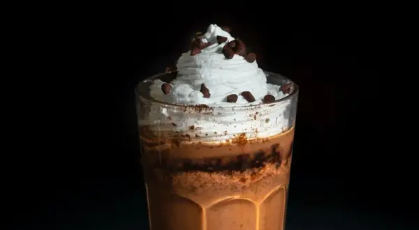 Ein köstlicher Eiskaffee mit viel Sahne und Schokostückchen, perfekt für heiße Tage.