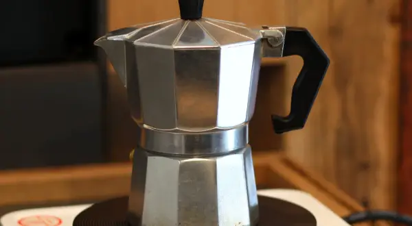 So einfach ist es, wie man einen Moka Pot benutzt: Aluminium-Kaffeekanne auf Herdplatte, bereit für aromatischen Kaffee.