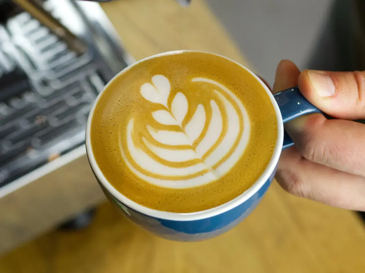 Eine Tasse Milchkaffee mit Latte Art, die das Ergebnis einer perfekten Milchkaffee Zubereitung zeigt.