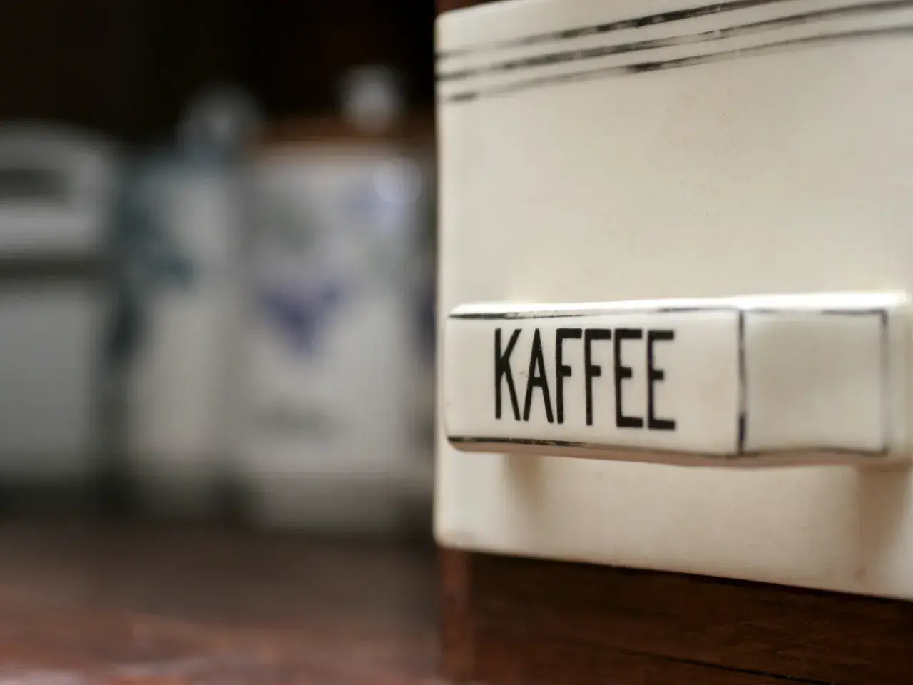 Ein Behälter mit der Aufschrift "KAFFEE" steht im Vordergrund. Im Hintergrund sind weitere Vorratsdosen zu sehen. Man fragt sich, ob Kaffee schlecht werden kann.