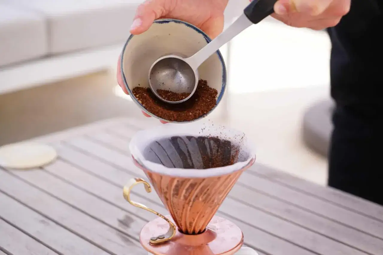 Kaffeezubereitung: Gemahlene Espressobohnen werden in einen Filter gegeben, um normalen Kaffee zu machen.