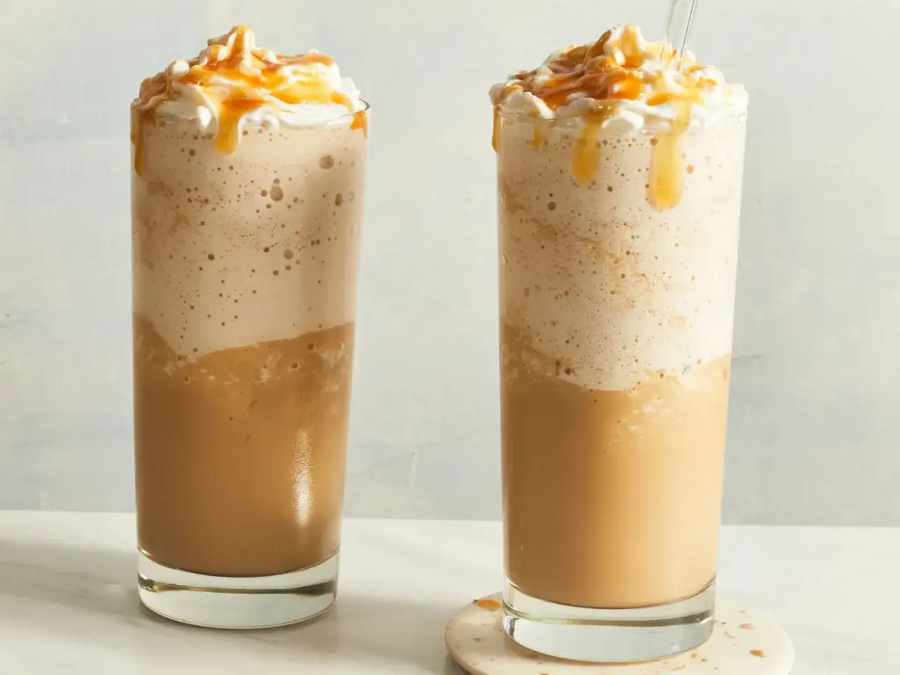 Zwei cremige Caramel Frappuccinos mit Sahne und Karamellsauce, bereit zum Genie&szlig;en.