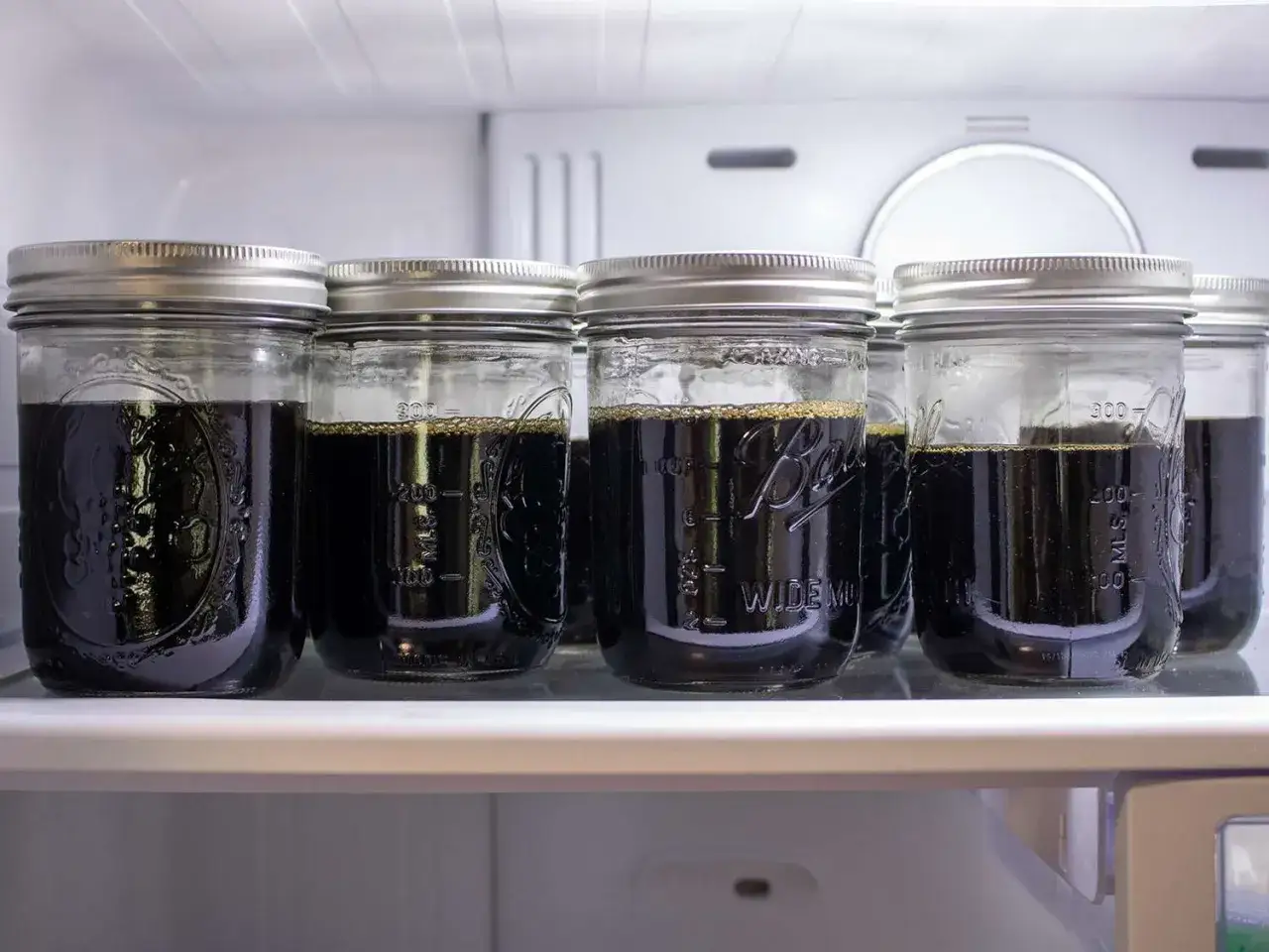 Sechs Gl&auml;ser mit dunklem, kaltem Kaffee stehen im K&uuml;hlschrank. Perfekt, um bald alten Kaffee zu trinken.