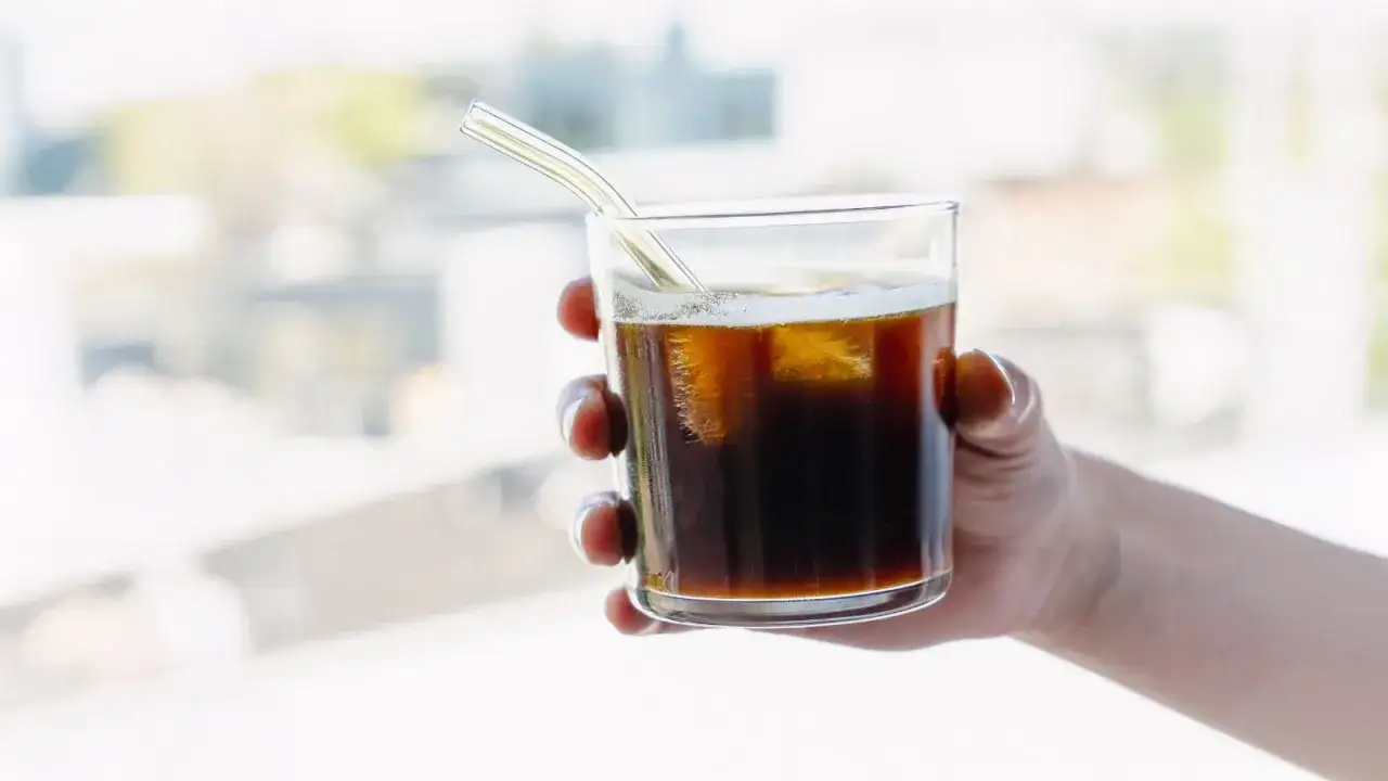 Erfrischender Iced Americano mit Eiswürfeln und Strohhalm. Perfekt für ein schnelles iced americano rezept.
