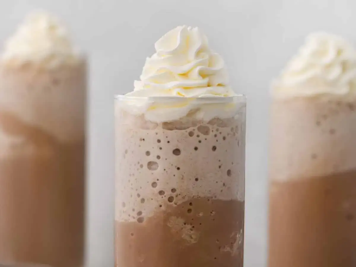 Drei cremige Frappuccinos mit Sahnehaube. Ein Frappuccino ist ein eisgekühlter Kaffee-Mix, perfekt für heiße Tage.