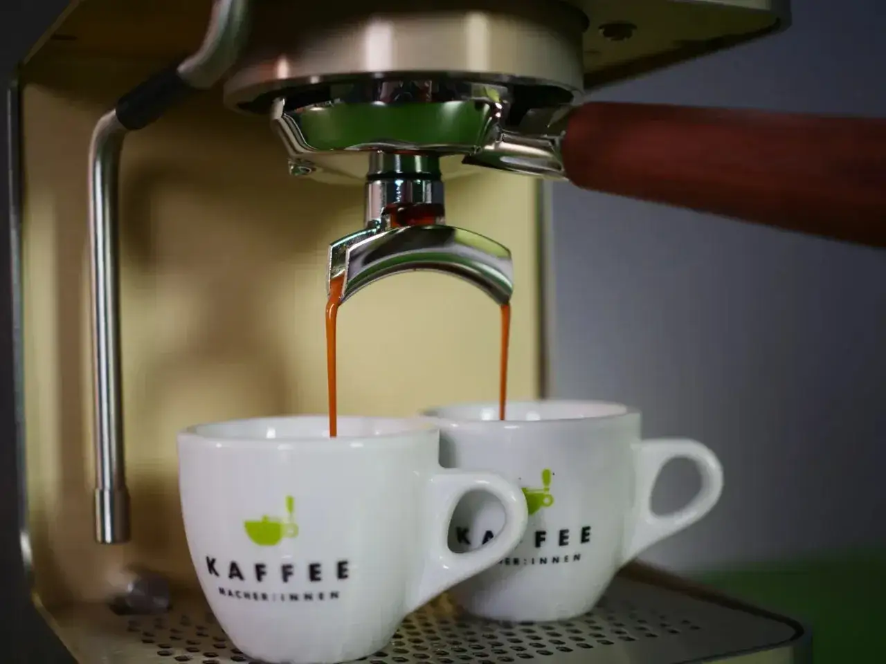 Zwei Tassen werden mit einem intensiven Ristretto zubereitet. Der Espresso flie&szlig;t aus der Espressomaschine in die kleinen wei&szlig;en Tassen.