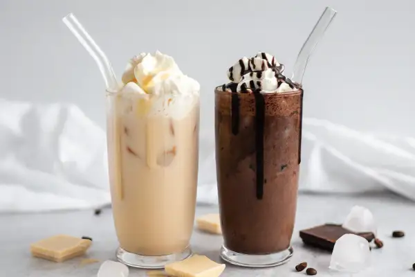 Zwei eisgekühlte Getränke, ein heller und ein dunkler, mit Sahne und Schokoladensauce. Perfekt für Caffè Mocha Rezepte.