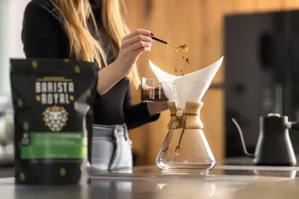 Frau bereitet Kaffee mit einer Chemex zu. Die Frage, ob man mit Espressobohnen normalen Kaffee machen kann, wird hier beantwortet.